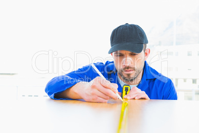 Handyman measuring wood board