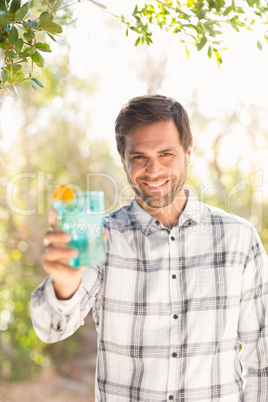 Happy man smiling at camera with drink