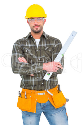 Manual worker holding spirit level with arms crossed