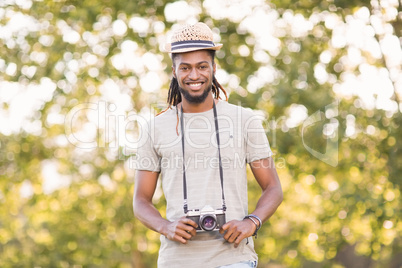 Handsome hipster using vintage camera