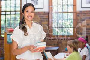 Pretty teacher smiling at camera in library