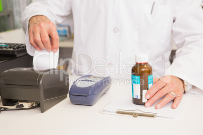 Pharmacist holding jar of medicine and receipt