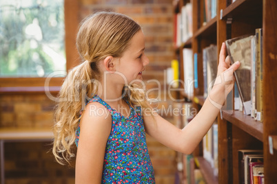 Cute little girl selecting a book