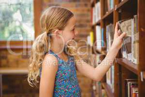Cute little girl selecting a book