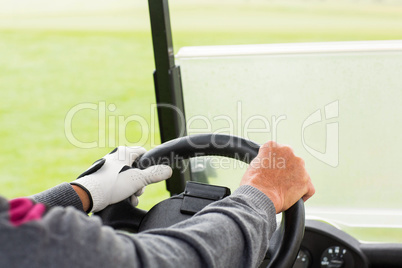 Golfer driving his golf buggy forward