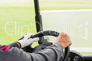 Golfer driving his golf buggy forward