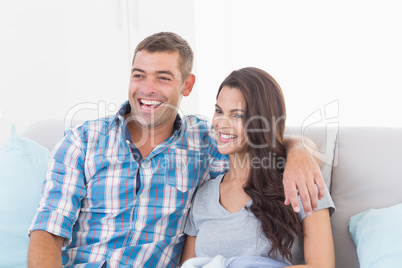 Loving couple watching TV on sofa