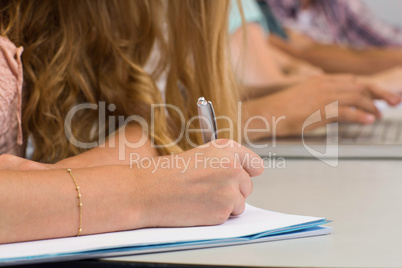 Students writing notes in classroom