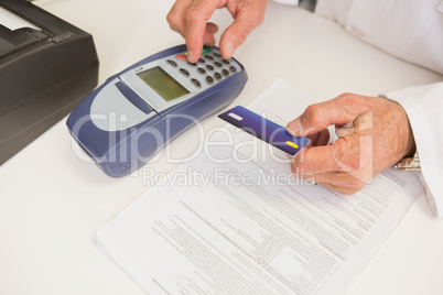 Pharmacist using keypad and holding credit card