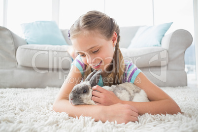 Girl playing with rabbit in living room