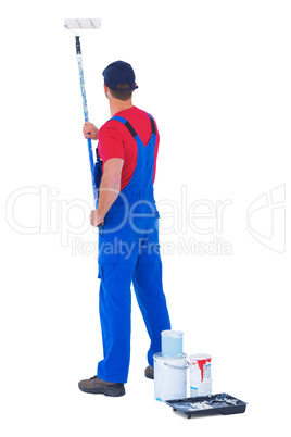 Rear view of handyman painting with roller on white background