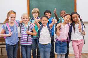 Cute pupils smiling at camera in classroom