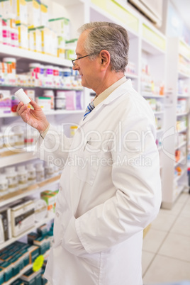 Smiling senior pharmacist holding medication