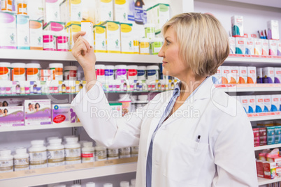 Smiling pharmacist looking at medicine