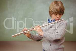 Little boy playing flute in classroom