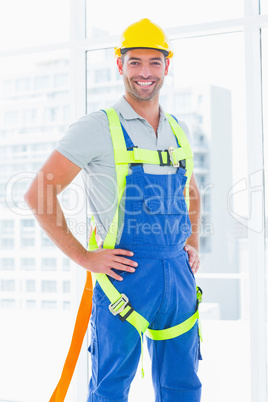 Construction worker wearing safety harness in office