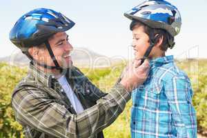 Father attaching his son cycling helmet