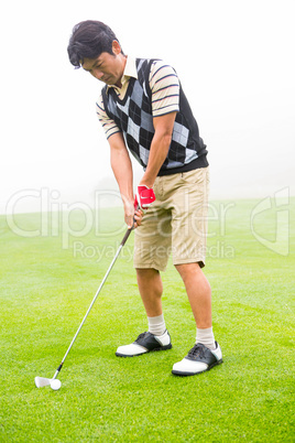 Concentrating golfer lining up his shot