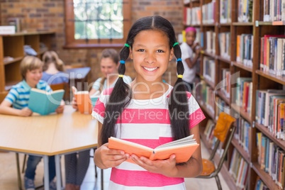 Cute pupil looking for books in library