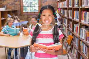 Cute pupil looking for books in library