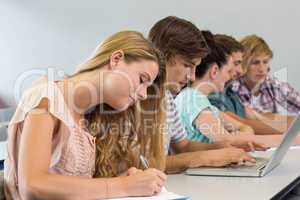 Students writing notes in classroom