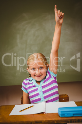 Little girl raising hand in classroom