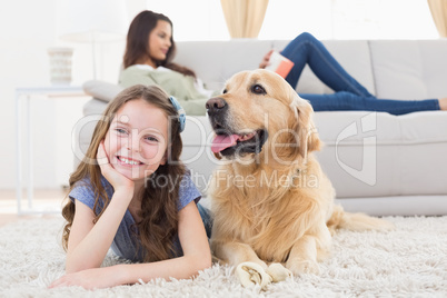 Girl with dog on rug while mother relaxing at home