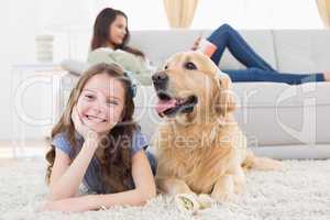 Girl with dog on rug while mother relaxing at home