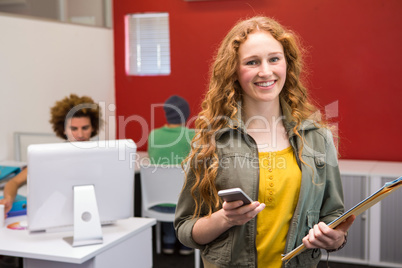 Beautiful casual businesswoman text messaging in office