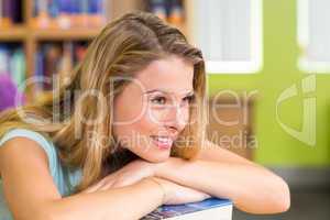 Thoughtful pretty female student in library