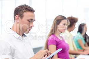 Male student using digital tablet in computer class