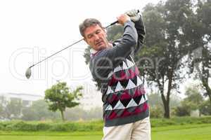 Golfer swinging his club on the course