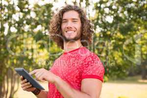 Handsome hipster using tablet pc in the park