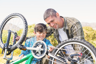 Father and son repairing bike