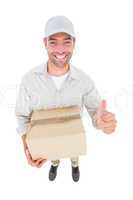 Handsome delivery man with cardboard box gesturing thumbs up