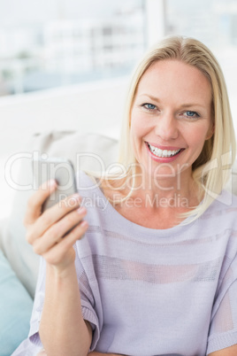 Portrait of smiling woman text messaging through smart phone