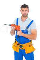 Confident male carpenter in overall holding drill machine