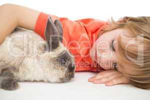 Cute boy lying arm around bunny