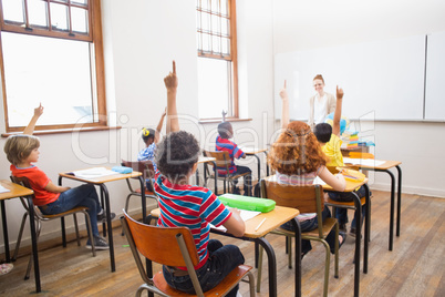 Pupils raising their hands during class