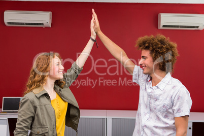 Casual businessman and woman high fiving