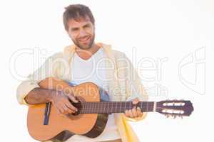 Happy man smiling at camera playing guitar