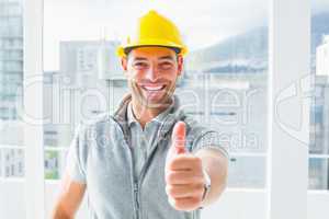Manual worker gesturing thumbs up in building