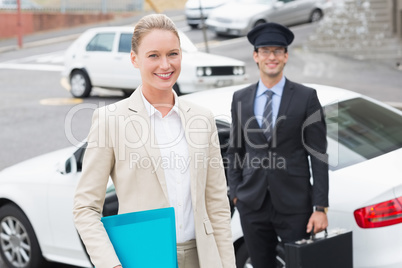 Businesswoman and her chauffeur smiling at camera