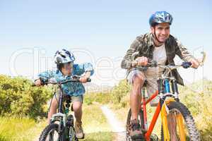 Father and son biking through mountains