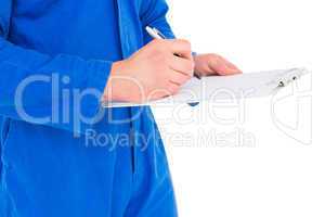 Male mechanic writing on clipboard