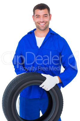 Mechanic holding tire on white background