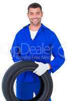 Mechanic holding tire on white background
