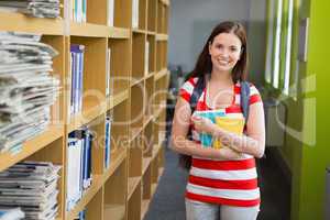 Student smiling at camera in library