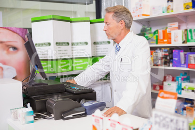 Senior pharmacist using the computer