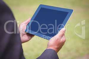 Businessman holding tablet in the park